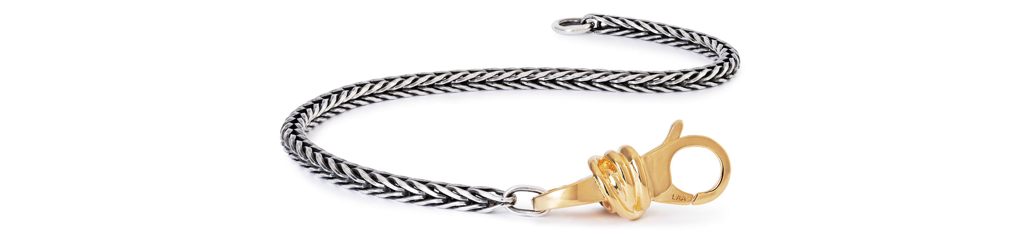 Sterling silver bracelet with gold-plated Lucky Knot clasp on white background
